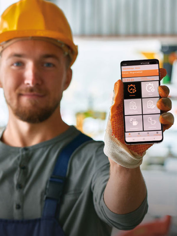 Handwerker mit Helm zeigt die mobile Zeiterfassung auf dem Smartphone